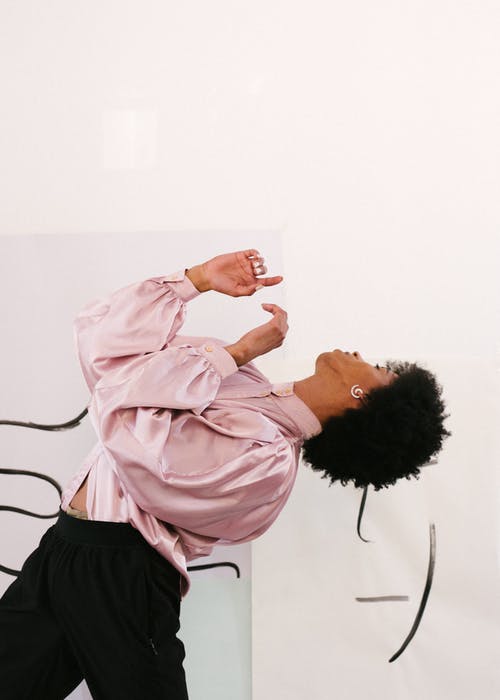 Sensual slim queer man dancing in modern studio